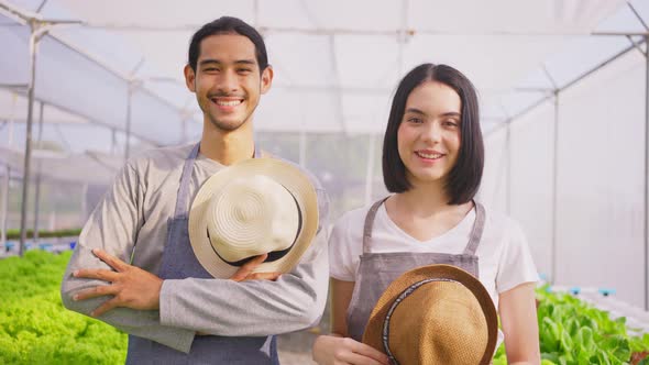 Portrait of Two Asian couple farmers owner working in vegetables hydroponic farm with happiness.