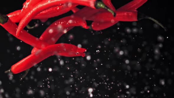 The Super Slow Motion of the Red Chilli Pepper Rising Off with Drops of Water