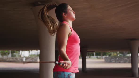 Caucasian woman working out under a bridge