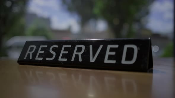 RESERVED sign placing on the cafe table with city view window.