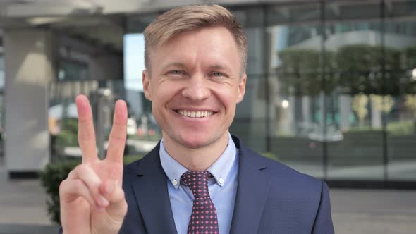 Victory Sign by Businessman