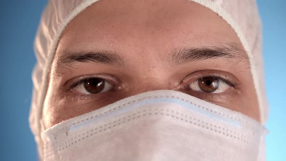 Man in Protective Suit Straightens Medical Mask on His Face