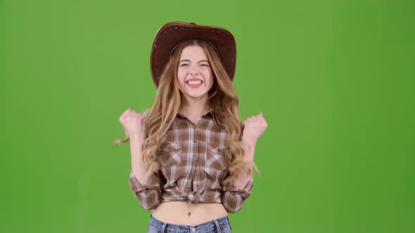 Girl in the Cowboy Hat Rejoices at the Victory. Green Screen