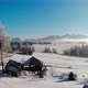 Aerial View of Aged Wood Buildings on Snowy Terrain in Mountains with Bright Blue Sky - VideoHive Item for Sale