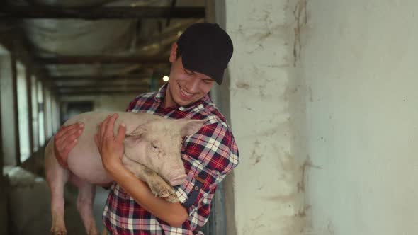 Joyful Farmer Holding His Favorite Piglet in His Arms