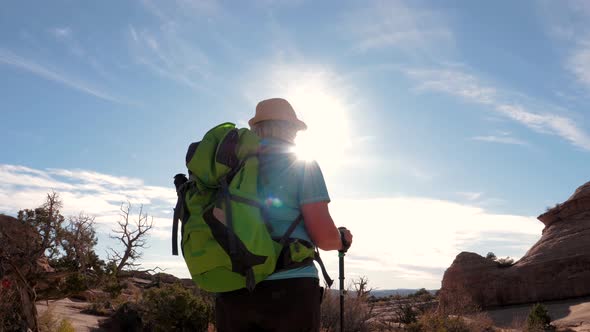 Tourist Hiking On Orange Sandstone In Desert At Sunset