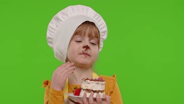 Child Girl Kid Dressed As Professional Cook Chef Showing Eating Tasty Handmade Strawberry Cake