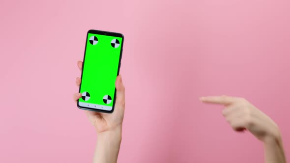 Hand holding a smartphone with a vertical green chrome screen and pointing a finger at the screen