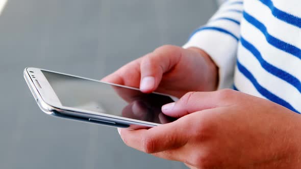 Mid-section of school kid using mobile phone