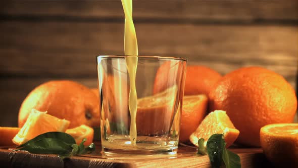 A Stream of Orange Juice Pours Into the Glass
