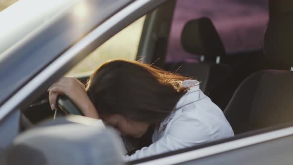 Nervous Woman in Car Knocks on Handlebar By Fingers and Leans Head on It