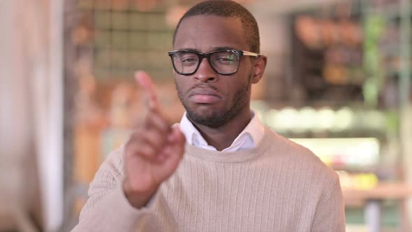 Portrait of Serious African Man Saying No By Finger Sign