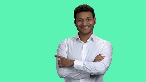 Smiling Dark-skinned Businessman Pointing at Copy Space.