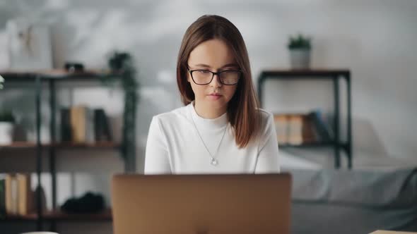 Woman Sitting at Table and Working on Laptop