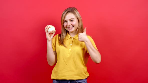 Cute and Slightly Fat Girl in a Yellow T-shirt Who Holds a White Onion in Her Hand