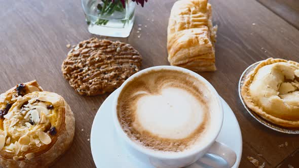 Top View Cup of Hot Coffee Cappuccino on Wooden Table with Bakery Pastry Items