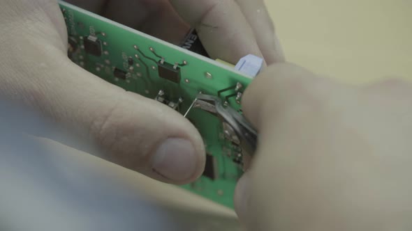 A Worker Is Working on the Production of an Electronic Board. Close-up.