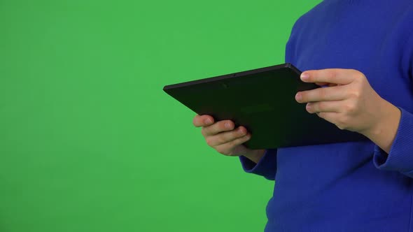 A Young Boy Looks at a Tablet - Closeup - Green Screen Studio