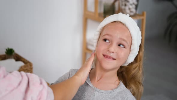 Mother Helping Daughter To Apply Creme on Face