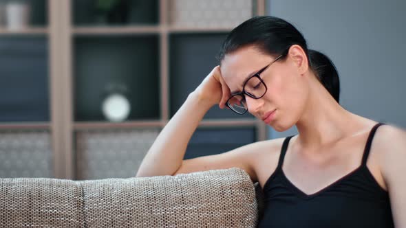 Upset Asian Woman Sitting on Couch at Home Feeling Pain Worried Problem Suffering Migraine