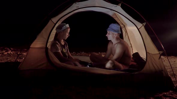 Son and Father in a Tent at Night