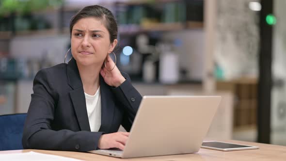 Tired Indian Businesswoman with Laptop Having Neck Pain in Cafe 