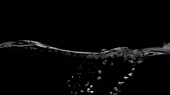 Water surface splash against black background. Slow Motion.