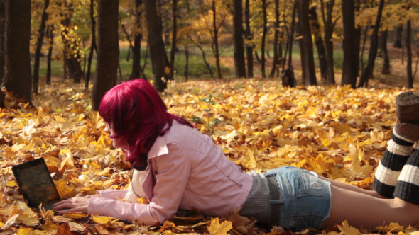 Young Girl with Laptop in Autumn Park