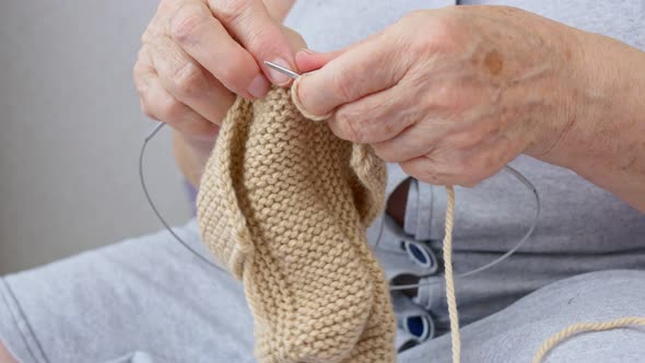 Closeup of a Grandmother's Hand Knitting a Warm Sweater to Her Grandchildren