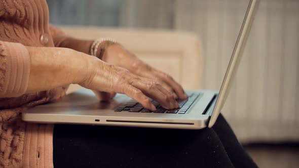 Senior Woman Hands Typing On Laptop Keyboard. Mature Woman Using Computer Browsing Social Networks
