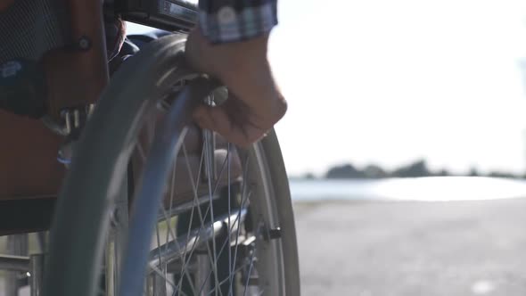 A Man in a Wheelchair Walks on the Waterfront