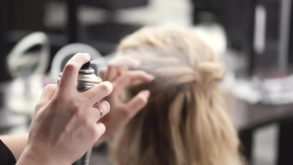 Hairdresser Doing Hairstyle for Female Client in Beauty Salon