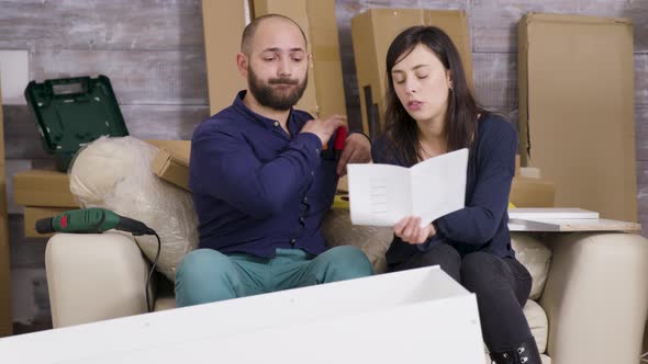 Girlfriend and Boyfriend Assembling Furniture in Their New Apartment