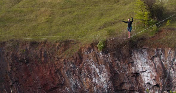 Sportsman Is Slacklining Over a Pit Walking on a Tightrope Extreme Sports