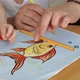 Close Up of Womens and Childrens Hands Draw Goldfish with Colored Pencils on Paper - VideoHive Item for Sale