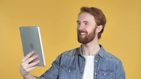 Video Chat By Redhead Man Via Tablet Yellow Background