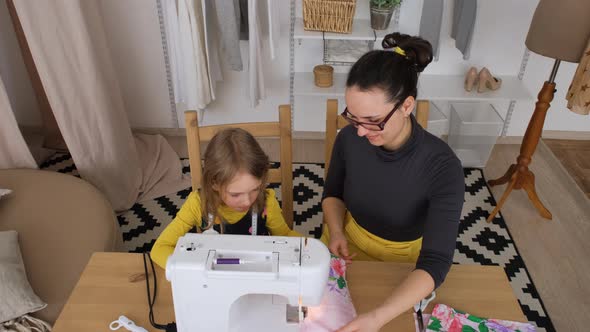 Mother Teaches Daughter How to Use Sewing Machine