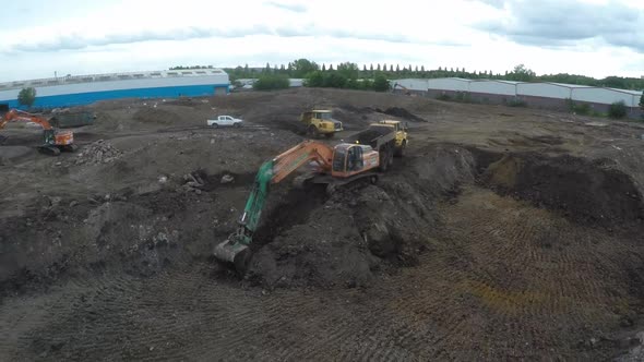 Aerial Tracking shot of Excavators digging the ground