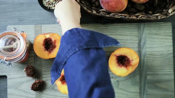 Cutting peaches in half for making grilled peaches.