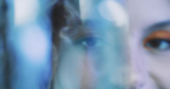 Close up of a beautiful girl dancing behind a glitter curtain