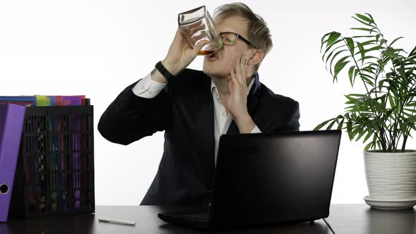 Tired Drunk Disheveled Businessman Working Hard in Office and Drink Alcohol