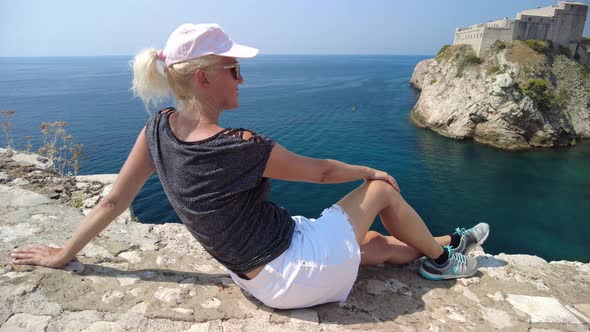 Woman Sitting on Top of Dubrovnik City of Croatia