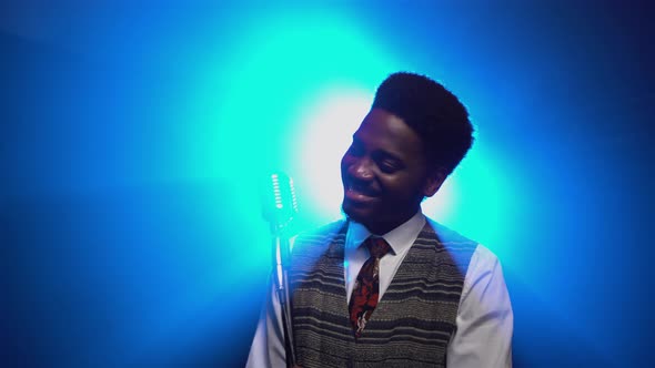 African American Man in a Stylish Suit Sings a Song Into a Retro Microphone