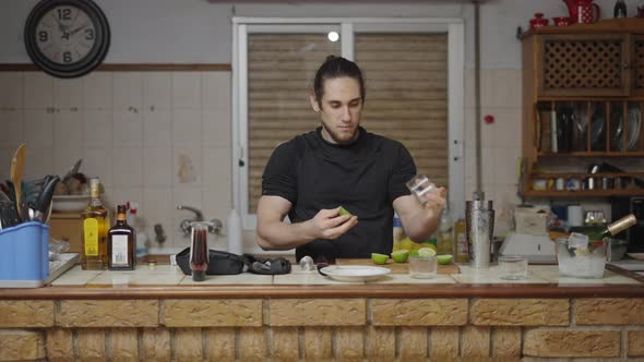 Young Barman Putting Lime and Sugar Around the Rim of a Cocktail Glass in Traditional Spanish