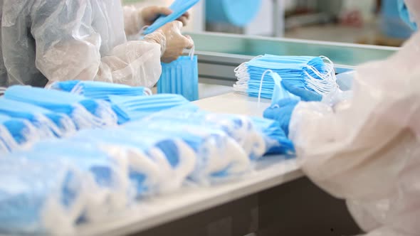 Industrial Production of Medical Masks - Staff Packing the Masks in Piles