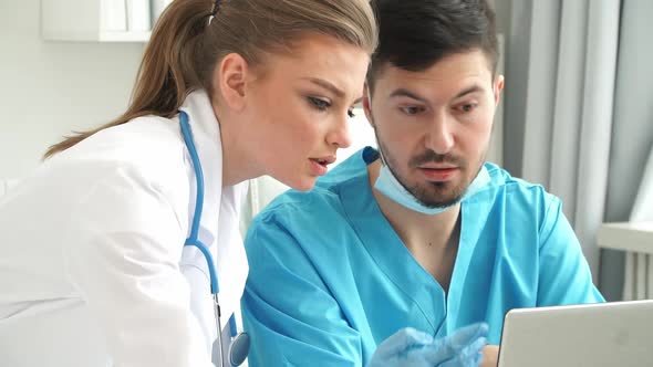 Team of Doctors in Work at Computer and Discuss Patients Diagnosis at Computer in Clinic