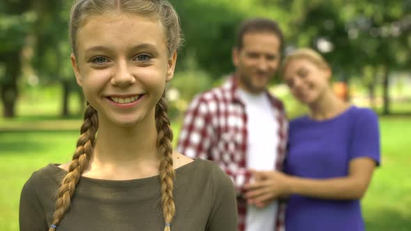 Pretty Girl Smiling on Background of Her Happy Parents, Loving and Caring Family