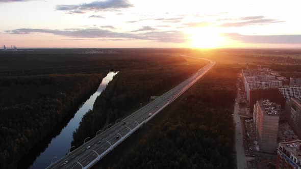 Long Highway with Driving Cars Among Woods with River