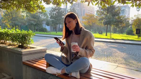 Woman With Coffee and Smartphone in the City