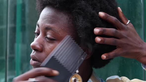 Stylish black woman brushing hair